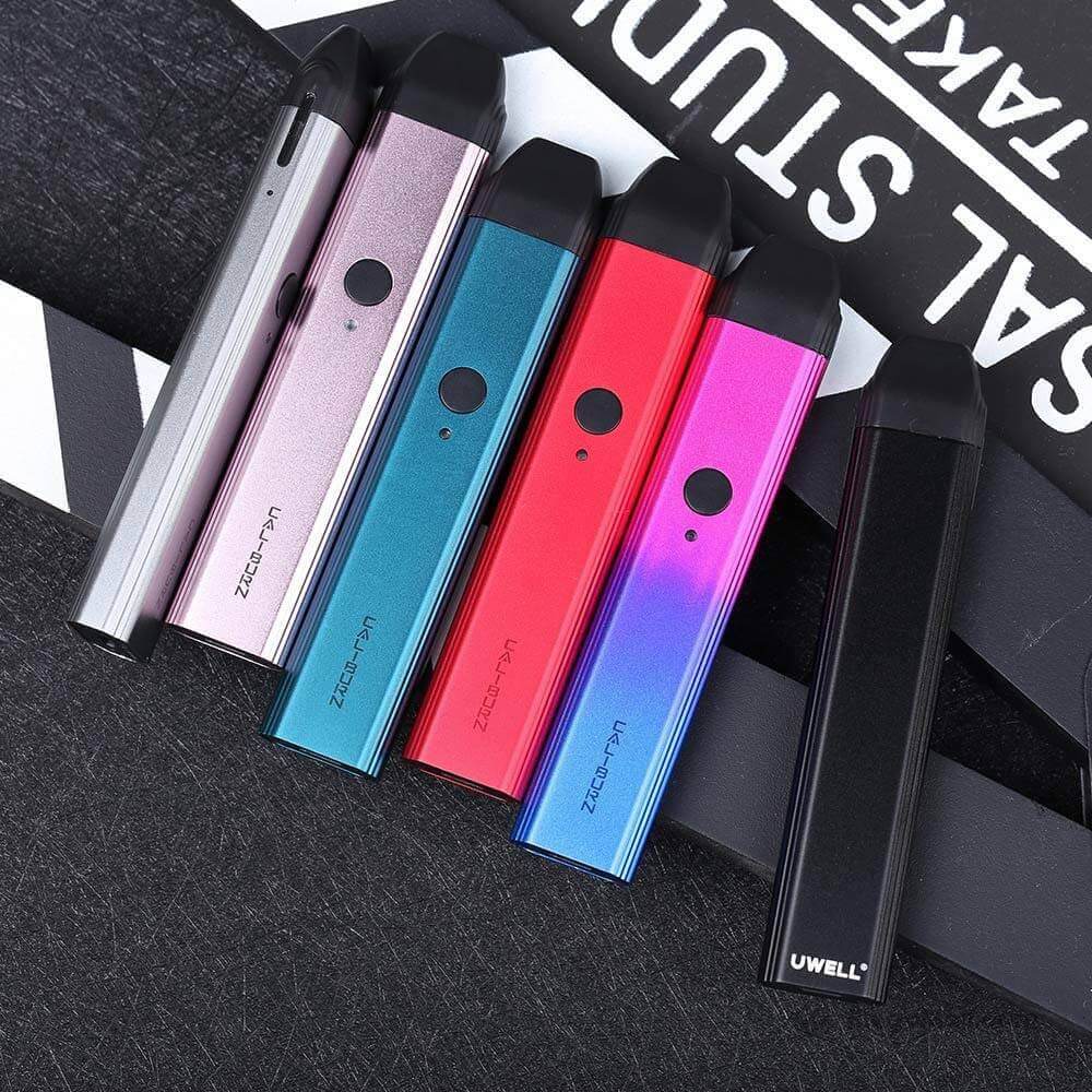 Six Uwell Caliburn pod vapes in assorted colours laid out on a dark textured background